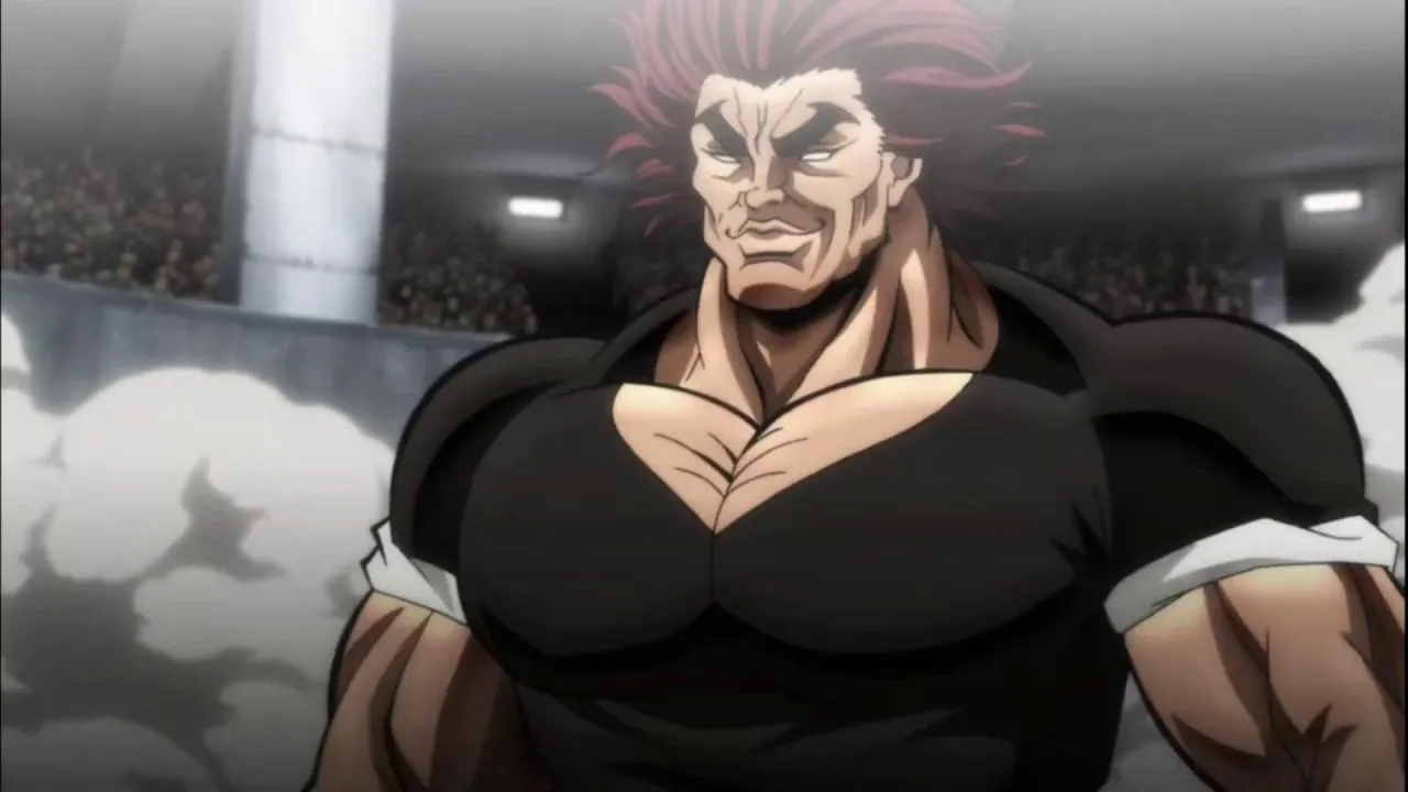 yujiro sorrindo de forma confiante enquanto usa sua blusa preta
