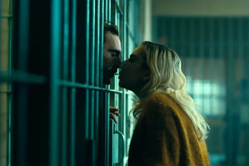 Personagens de Coringa: Delírio a Dois se beijando por meio das grades da prisão.