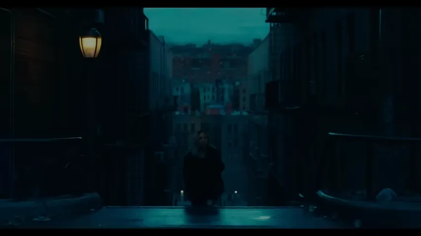 Imagem retirada do trailer de "Coringa: Delirio a dois" mostrando o momento em que Arlequina sobe as escadas referenciando o primeiro filme