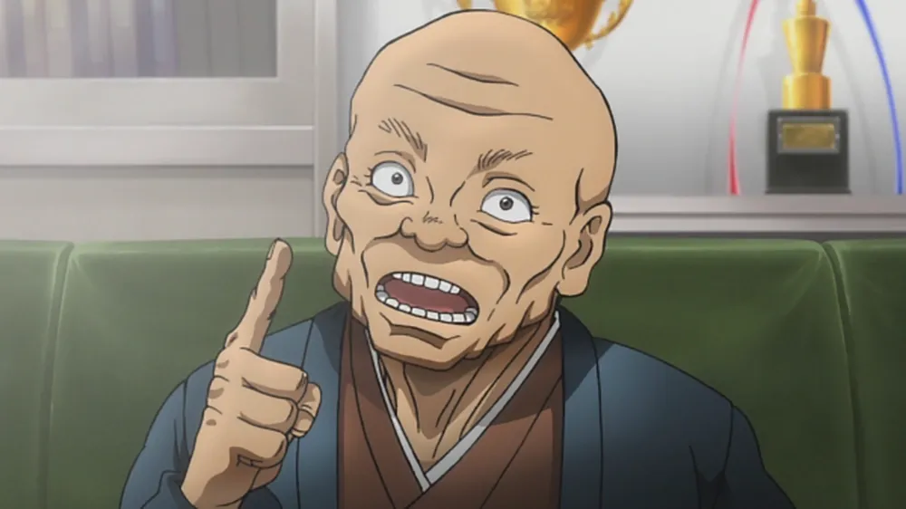 Tokugawa apontando seu dedo para cima. Ele está usando roupas de cor marrom e azul escuro.