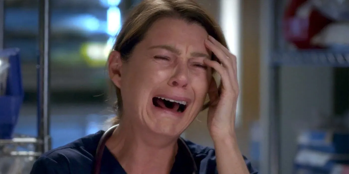 Meredith Grey, protagonista de Grey's Anatomy, chorando com a mão na cabeça.