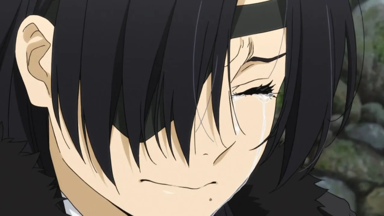 mulher de cabelos pretos e franja chorando de olhos fechados