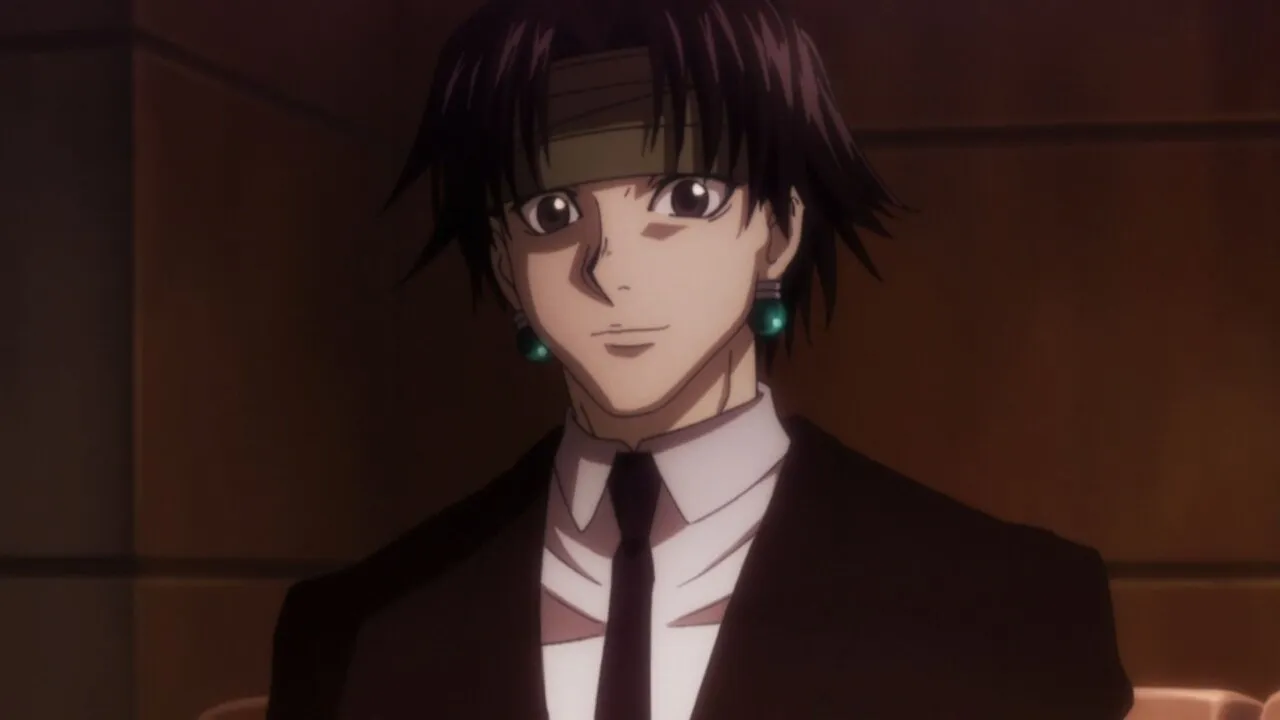 chrollo usando terno e sorrindo, aparentemente contente com algo