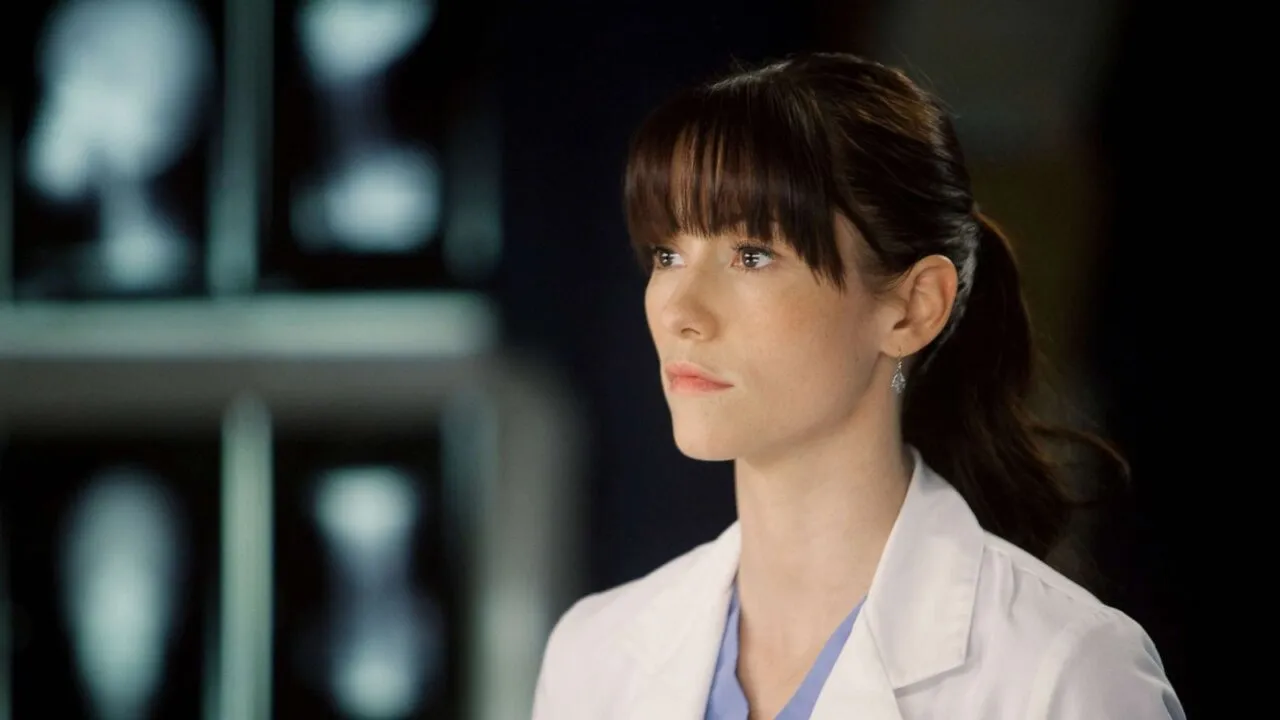 Personagem de Grey's Anatomy olhando para frente, com franja.