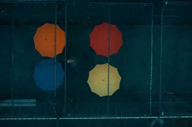 Imagem do trailer mostrando guarda chuvas coloridos uma referencia ao filme musical "Guarda- Chuvas do amor"