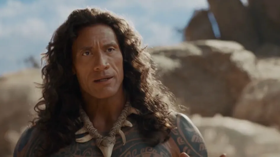 Homem tatuado de cabelos longos e cacheados olhando para frente