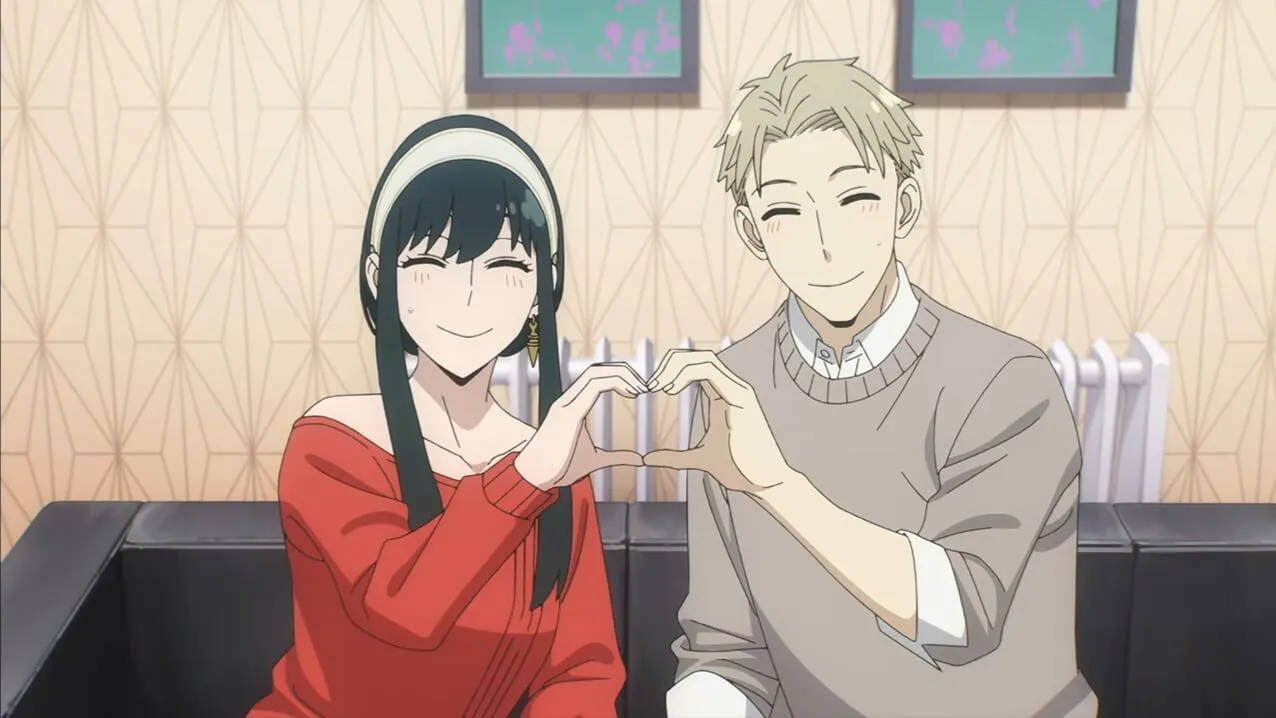 homem e mulher sentados no sofá fazendo coração juntando as mãos 