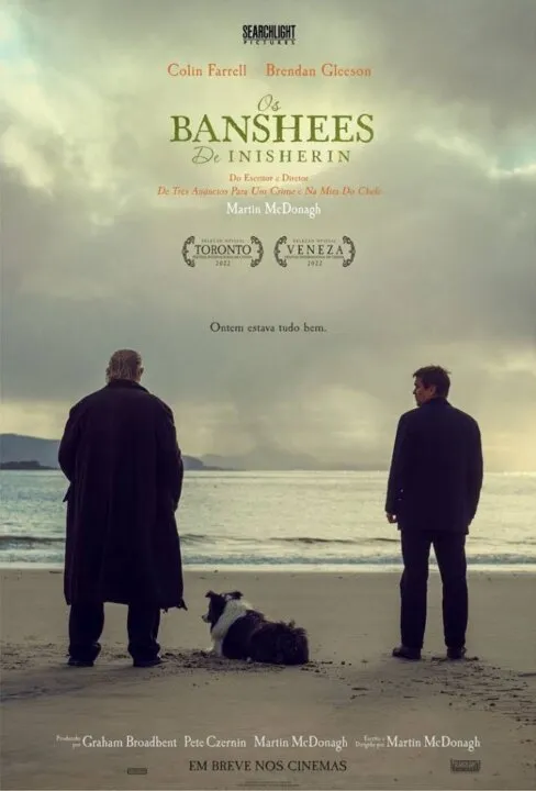 Dois homens em pé, em uma praia, acompanhados de um cachorro. Imagem é pôster oficial de divulgação do filme "Os Banchees de Inisherin"