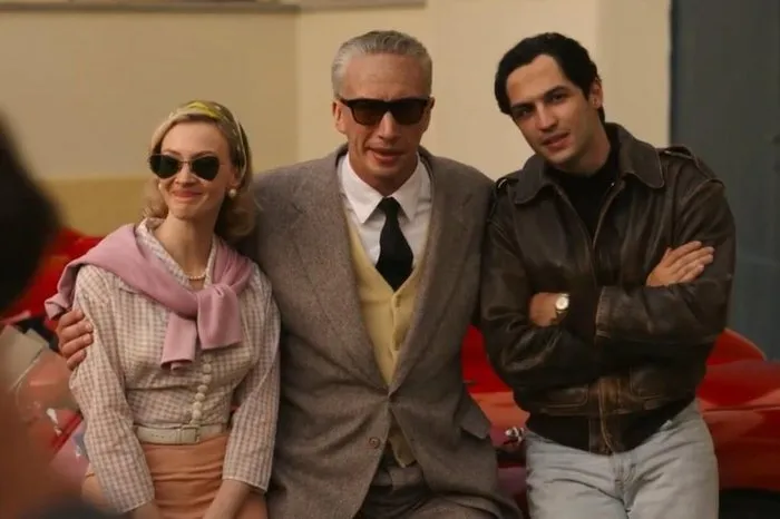 Imagem retirada do filme "Ferrari", mostrando os atores Adam Driver interpretando Enzo Ferrari, Gabriel Leone interpretando Alfonso de Portago e Sarah Gadon interpretando Linda Chirtian