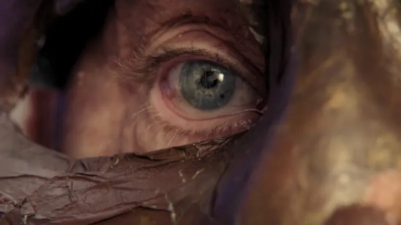 Homem de olhos azuis usando máscara e olhando para o lado
