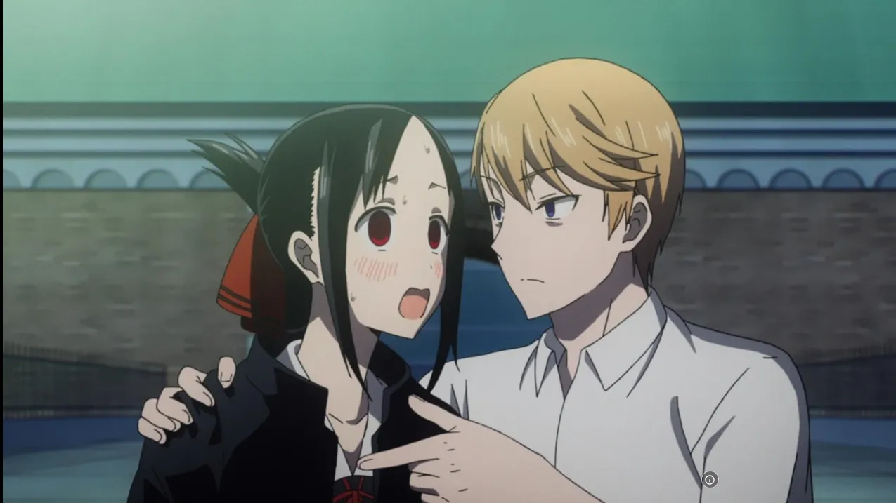 shirogane-com-seu-braco-no-ombro-de-Kaguya-enquanto-explica-algo-para-ela-e-ela-fica-com-vergonha