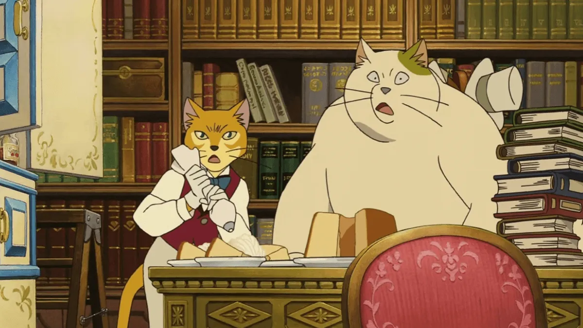 dois gatos sentados em uma mesa de boca aberta olhando para frente