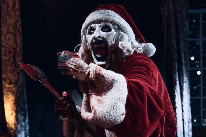 O Palhaço Art, de Terrifier 3, sorridente com roupa de Papai Noel.