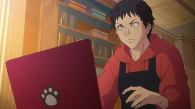 Homem de cabelos pretos e casaco vermelho olhando para frente e mexendo em notebook vermelho com desenho de pata de gato