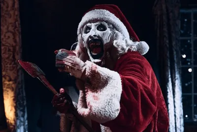 O Palhaço Art, de Terrifier 3, sorridente com roupa de Papai Noel.