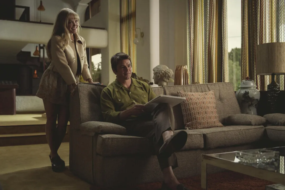 Imagem da nova temporada da série black mirror, ilustrando um homem e uma mulher sorrindo no sofa
