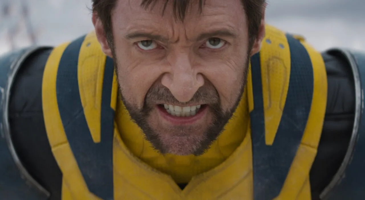 Personagem de Deadpool e Wolverine com expressão de raiva e uniforme amarelo.