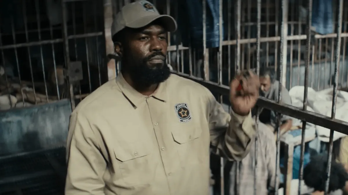 homem de casaco e boné com semblante de bravo levantando a mão