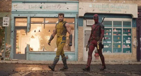 Deadpool e Wolverine andando nas ruas da cidade com seus uniformes.
