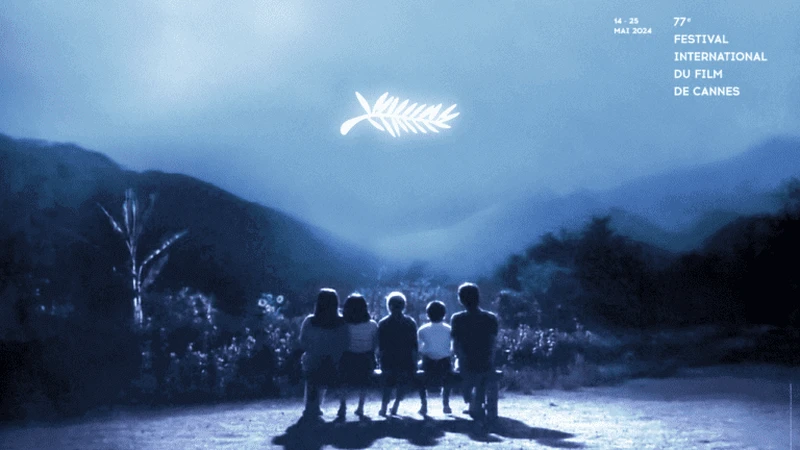Crianças sentadas em um banco observam o símbolo do Festival de Cannes no céu.