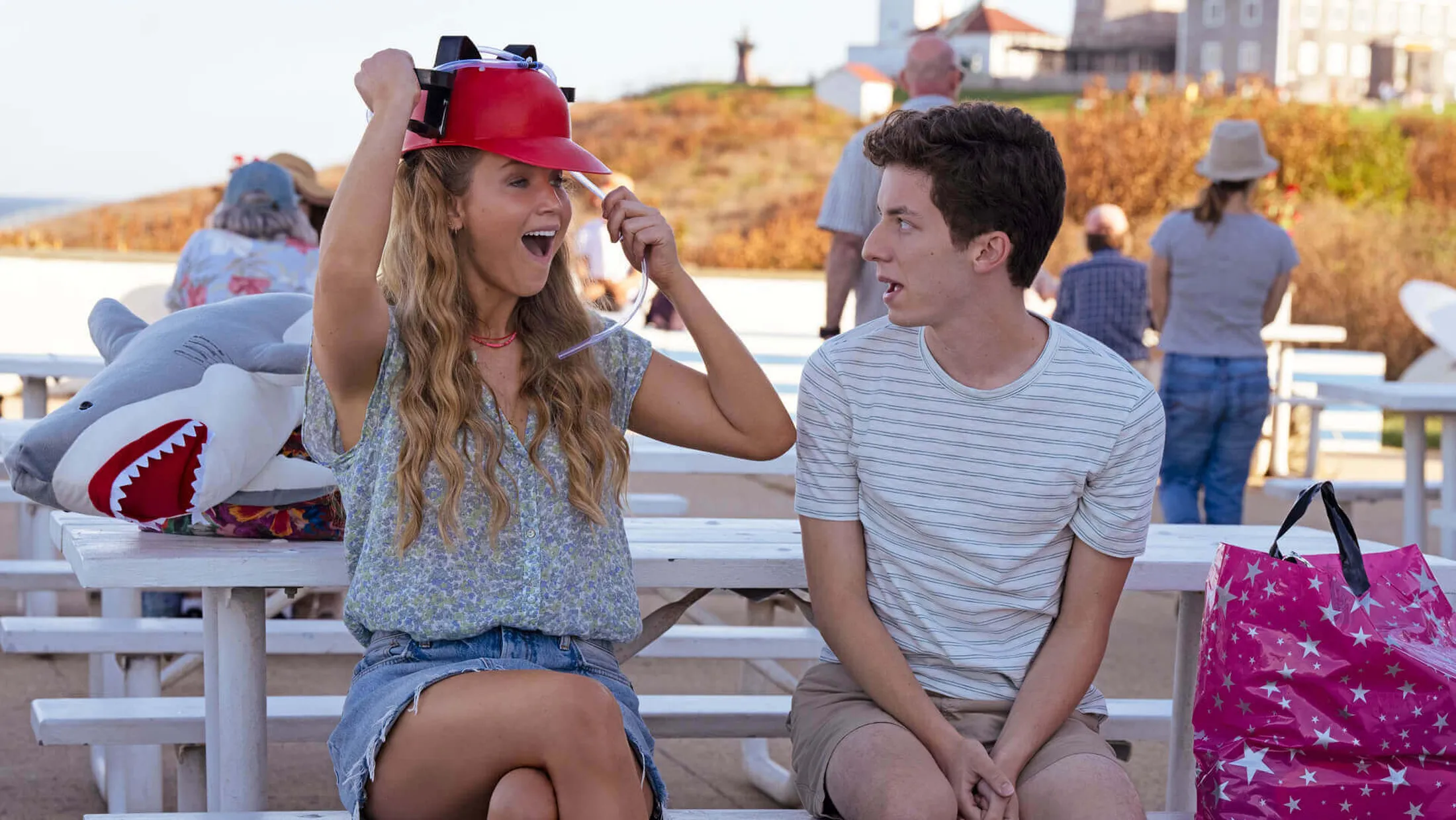 Imagem da atriz Jennifer Lawrence com chapéu vermelho sorrindo para o ator Andrew Feldman no filme de comédia "Que horas eu te pego?".